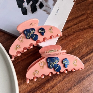 Pince à cheveux en acétate rose avec motif champignon bleu et détails de fleurs dorées