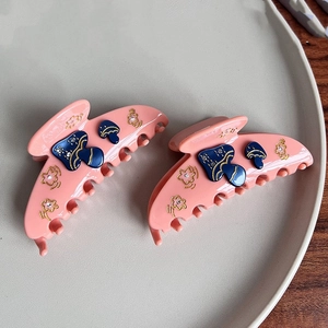Pince à cheveux rose en acétate avec motifs de champignons bleus et fleurs dorées