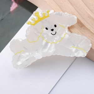 Détail d'une pince à cheveux petit caniche blanc avec couronne jaune nacrée