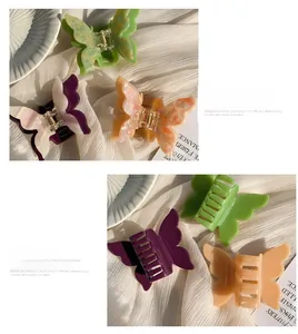 Detailed view of acetate butterfly hair claw clips with marble texture and metal spring