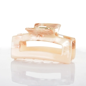 Detailed macro view of rectangle marble acetate hair claw with gold spring mechanism