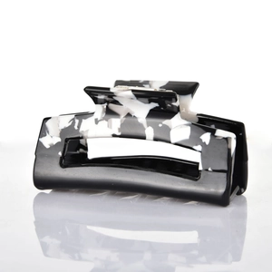 Detailed close-up of large acetate hair claw clip with black and white marble pattern