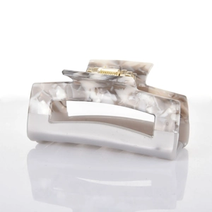 Close-up of marble pattern rectangular hair claw clip with golden metal spring