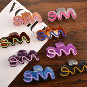 Set of 8 colorful acetate hair claw clips with marble texture on a dark wood surface