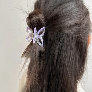 Detailed view of a purple marble butterfly hair claw clip styled on long brown hair