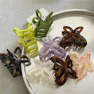 Variety of colorful acetate butterfly hair clips displayed on a metallic tray