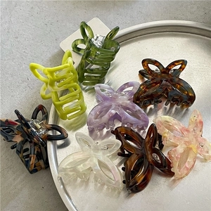 Chic acetate butterfly hair claws in various spring colors and patterns on a metal tray