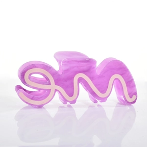 Macro view of purple marble acetate hair claw with unique wave design and pink accents