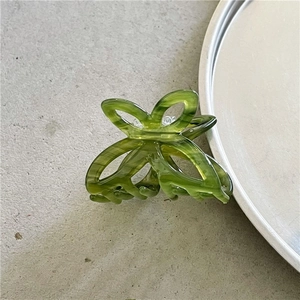Close-up of a green marbled acetate butterfly hair claw clip for half-up hairstyles