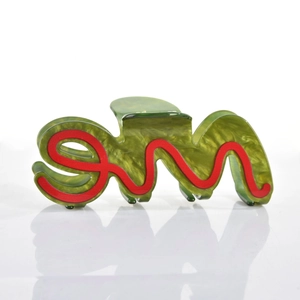 Macro shot of large acetate hair claw clip featuring green marble pattern and red wave line