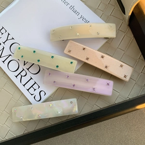 Lot de 5 barrettes en acétate avec strass colorés sur fond de livre minimaliste