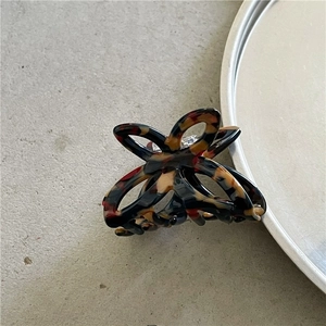 Detail view of small tortoiseshell acetate butterfly hair claw with silver metal spring