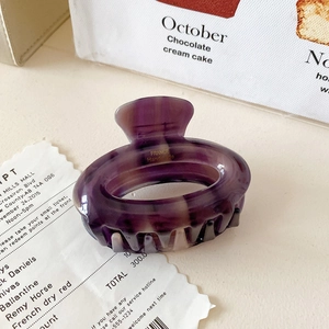 Detailed close-up of hollow oval hair claw clip with purple marble texture pattern