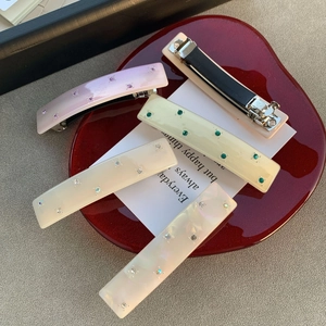 Barrettes élégantes en acétate avec strass brillants présentées dans un plateau
