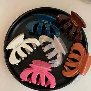 Set of 6 vintage acetate shark hair claws in assorted colors on a black tray