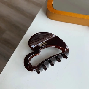 Dark brown heart-shaped acetate hair claw clip with golden Barrette La France text
