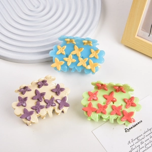 Three colorful flower claw clips in cloud design with pastel blue, beige and green colors