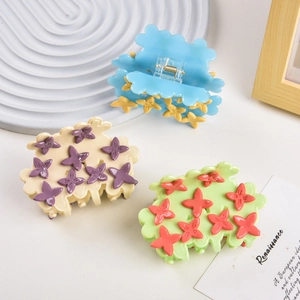 Detail view of acetate cloud hair clips in blue and cream with 3D floral accents