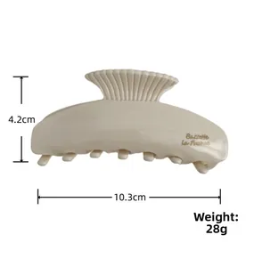 Detail view of large cream acetate hair claw clip with gold lettering and size dimensions