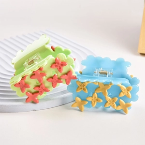 Close-up of cloud-shaped acetate hair claws with colorful 3D floral patterns
