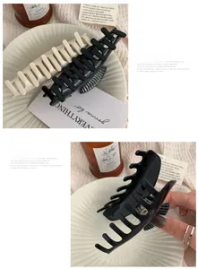 Detailed macro view of large acetate scallop hair claw clips in cream and shiny black colors