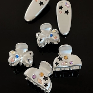 Retro star alloy hair clips with colorful zircons on a black glossy background