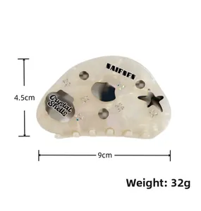 Detailed view of 9cm acetate hair claw clip with star patterns and crystal accents