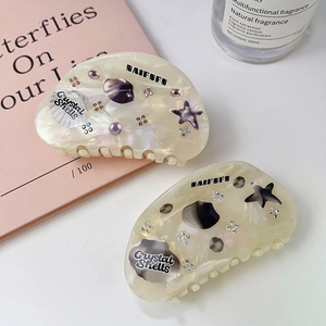 Shell and starfish shaped hair clips with pearlescent texture and rhinestone accents
