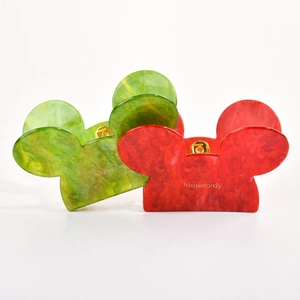 Detail of Mickey-shaped hair claws in red and green marble acetate with gold glitter