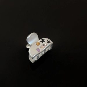 Close-up of star mini hair claw clip with colorful zircon and matte silver finish