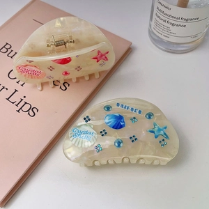 Elegant ocean-themed acetate hair claws with iridescent shell and starfish designs
