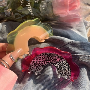 Elegant cantaloupe colored jelly large acetate claw clip on denim background with flowers