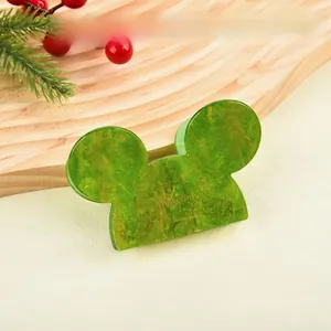 Detail of Mickey-shaped hair claw with dark green marble texture and gold glitters