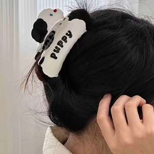 Détail de la pince à cheveux en forme de chiot avec texte PUPPY portée sur les cheveux