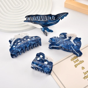 Détail de pinces à cheveux en acétate avec texture marbre bleu et motifs de baleine
