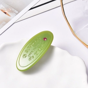Barrette ovale verte en acétate avec gravure SAVON et ornement de strass rose