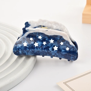 Pince à cheveux en acétate marbré bleu avec motif d'étoiles sur plateau blanc