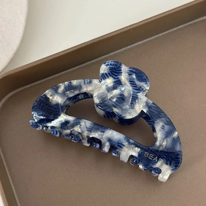 Vue détaillée de la pince à cheveux en acétate marbré avec décoration florale et diamant