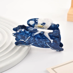 Détail d'une pince à cheveux artistique en acétate avec motif marbré bleu et blanc élégant