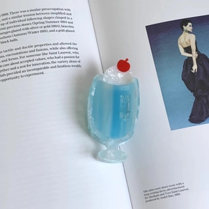 Close-up of cream soda acetate hair claw with white cream and red cherry on a magazine