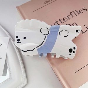 Détail d'une pince à cheveux en acétate motif petit chien blanc avec accents pailletés