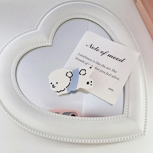 Détail d'une pince à cheveux motif chien mignon avec nœud bleu sur un miroir en cœur