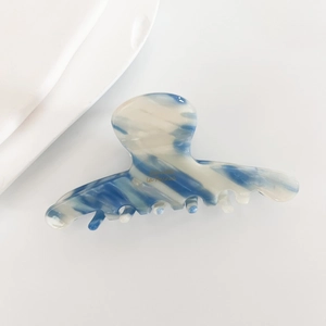 Detailed close-up of blue marble acetate hair claw clip with golden Bonjour inscription