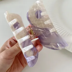 Detailed close-up of marble pattern acetate hair claw clip with purple and white swirls