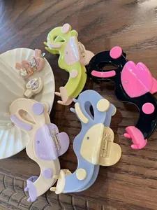 Détail de pinces à cheveux en acétate en forme de cœur et clips en strass sur bois