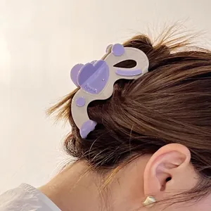 Détail d'une pince à cheveux en acétate avec cœur violet pour chignon élégant