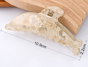 Vue détaillée d'une pince à cheveux dauphin de 10,9 cm en texture marbre crème