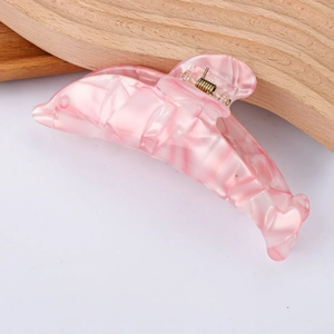 Vue détaillée de la pince à cheveux en forme de dauphin avec texture marbrée rose