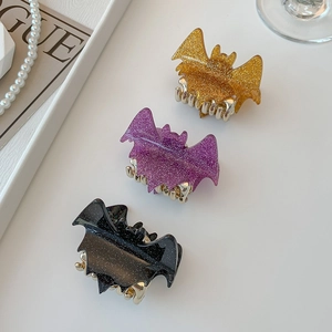Three glittery bat hair claws in gold, purple and black for Halloween styling