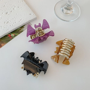Three Halloween bat hair claws in purple, orange and black with fine glitter details
